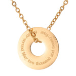 Gold necklace with a round pendant on a white background engraved with a date in full text