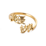 A gold-colored two-name ring with Japanese characters on it, displayed on a white background.