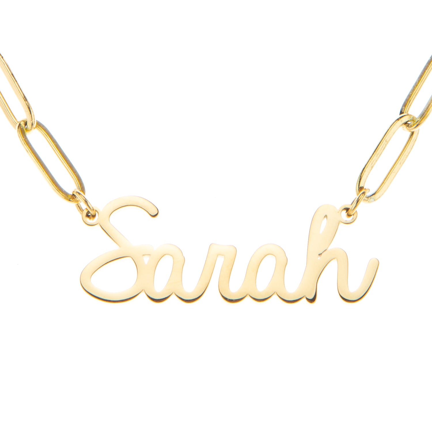 A gold-plated personalized name necklace with the name 'Sarah' written in a cursive script font, attached to a paperclip chain.