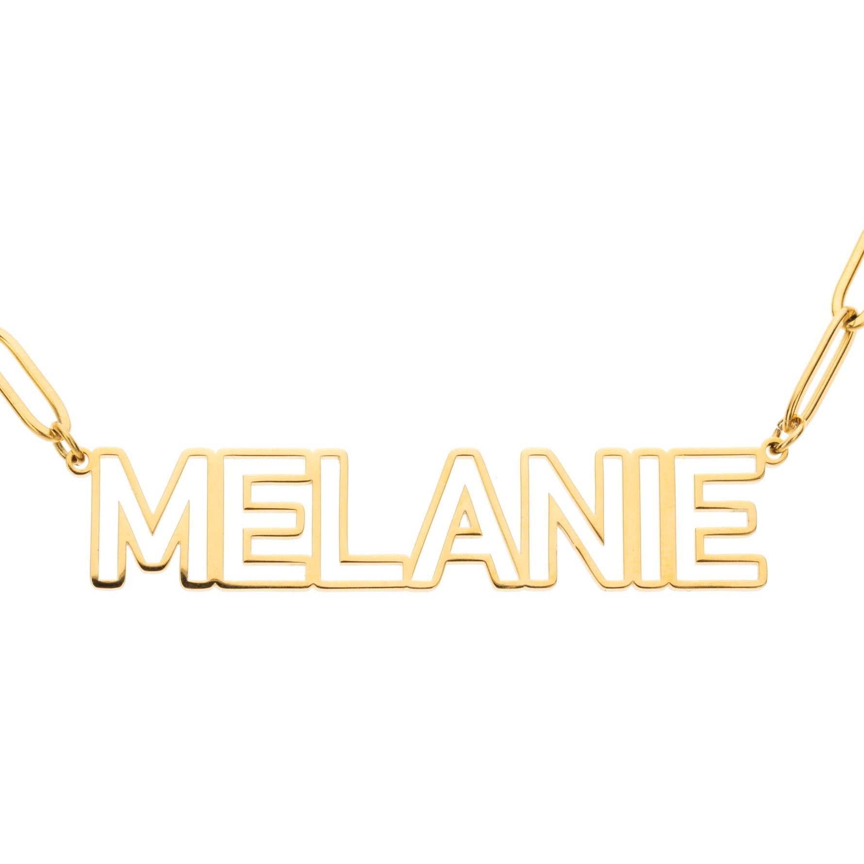 A gold necklace with the name 'MELANIE' written in bold, hollowed uppercase letters connected by a solid horse-link chain.
