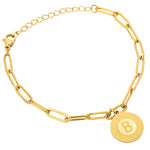 A gold-colored bracelet with a circular charm featuring an initial 'B' in the center, displayed on a white background.